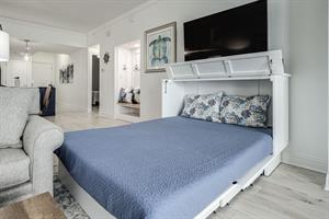 Murphy queen bed pulls out from sleeper cabinet in living room