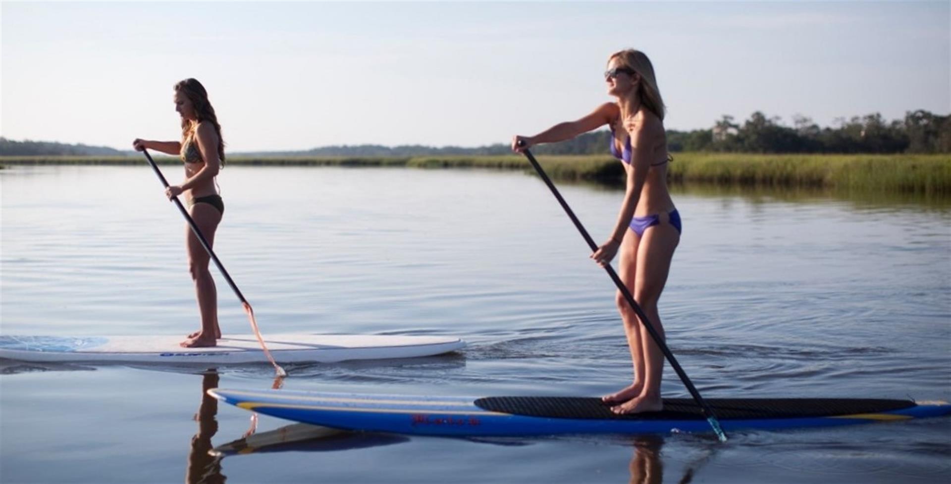 Two girls paddleboarding on Bald Head Island