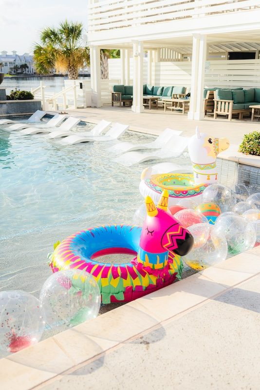 Colorful fiesta-themed llama and pinata pool floats in the resort-style community pool at Cinnamon Shore's Fiesta by the Shore celebration in Port Aransas, Texas