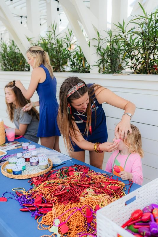 Children enjoying a colorful bead and craft activity station at the Fiesta by the Shore Cinco de Mayo event at Cinnamon Shore in Port Aransas, Texas