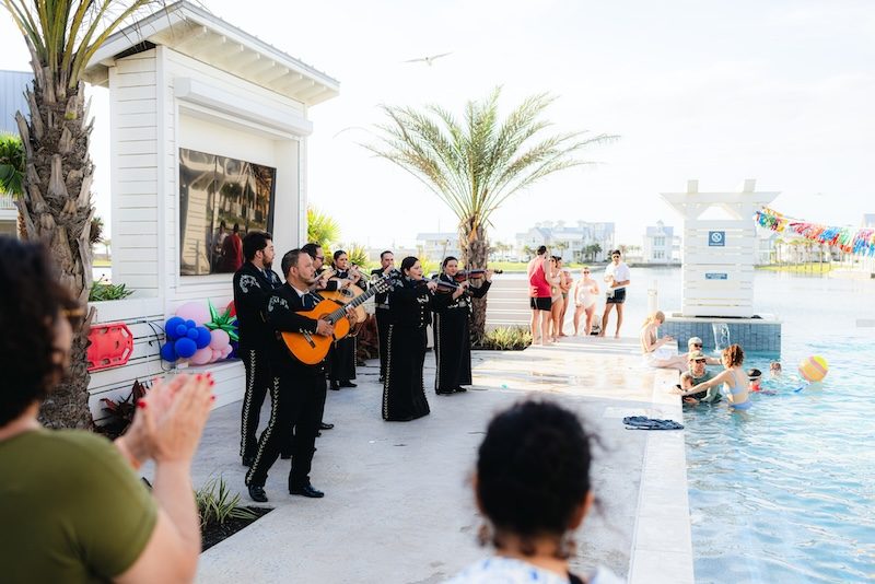 Guests clapping along as a mariachi band performs by the community pool during the Fiesta by the Shore Cinco de Mayo celebration at Cinnamon Shore in Port Aransas, Texas