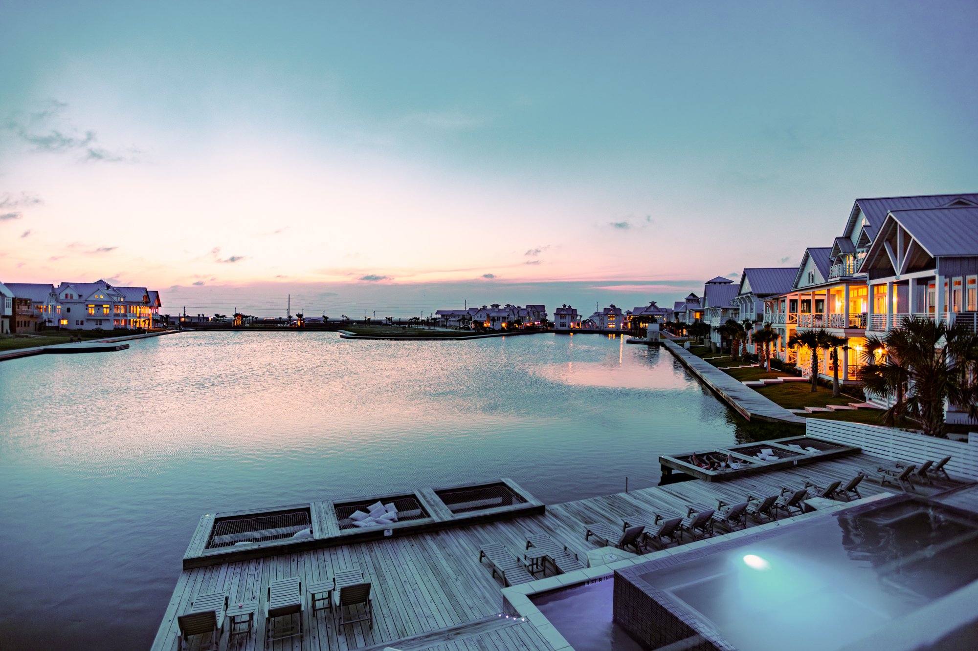 Dusk view of Cabana Pool at Cinnamon Shore South beside the lake in Port Aransas, Texas