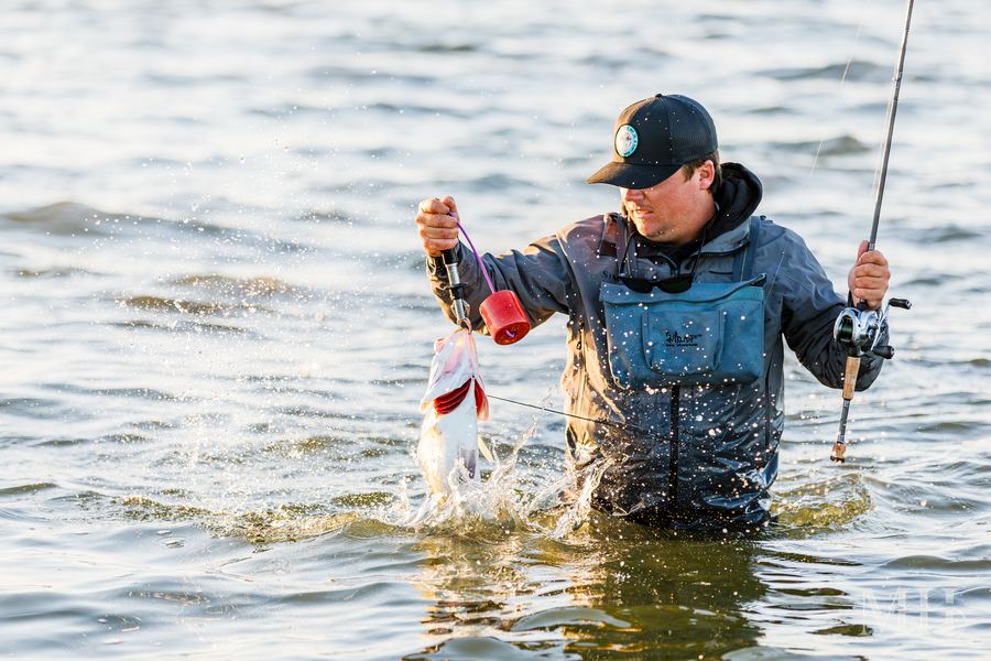 Capt. Hunter Campbell of Coastal Hooker Guide Service holding a speckled trout on the Texas Coastal Bend