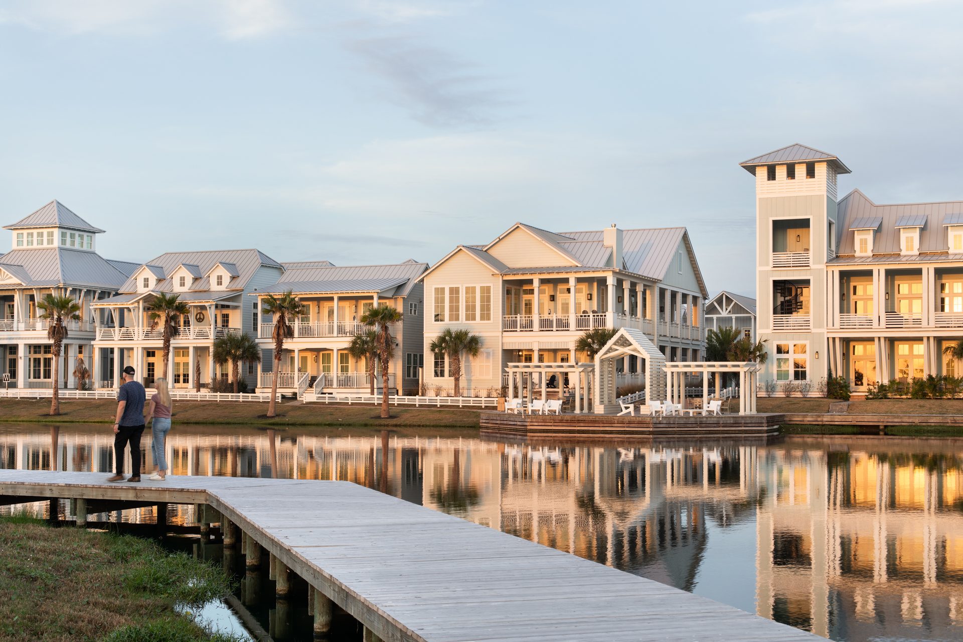 Couple walking the lakefront boardwalk at Cinnamon Shore South in Port Aransas at golden hour