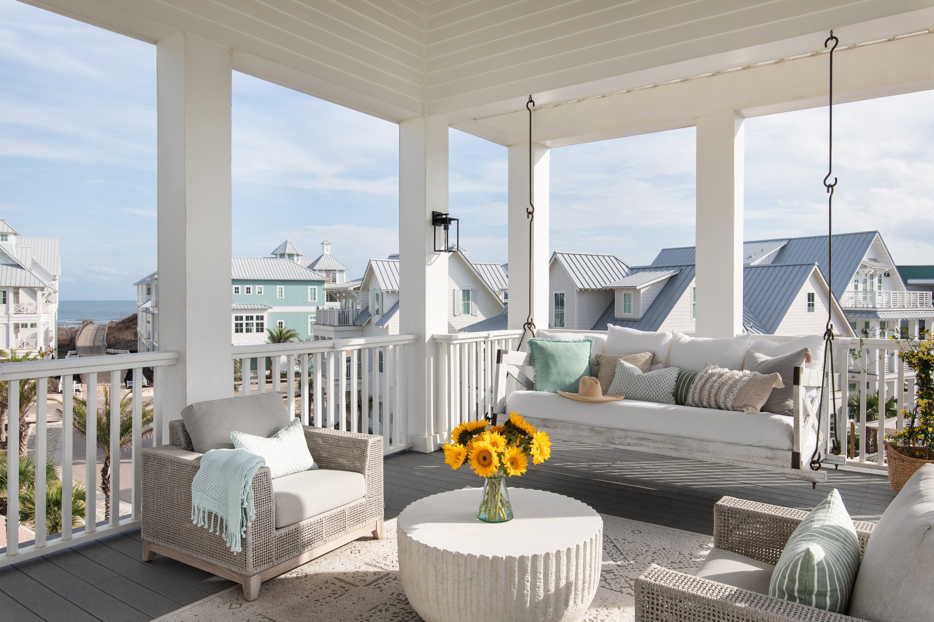 Covered porch with a swing bed and ocean view at Cinnamon Shore in Port Aransas