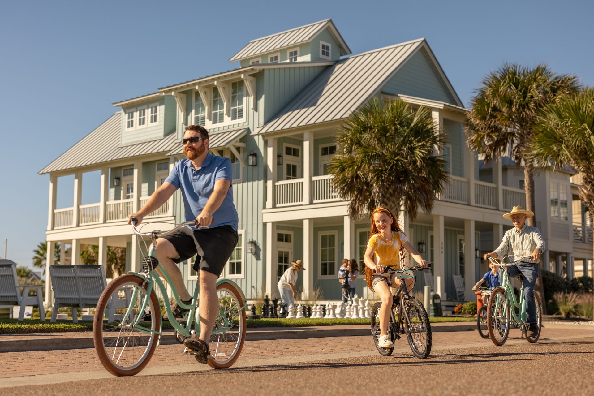 Family bike ride past coastal homes at Cinnamon Shore in Port Aransas