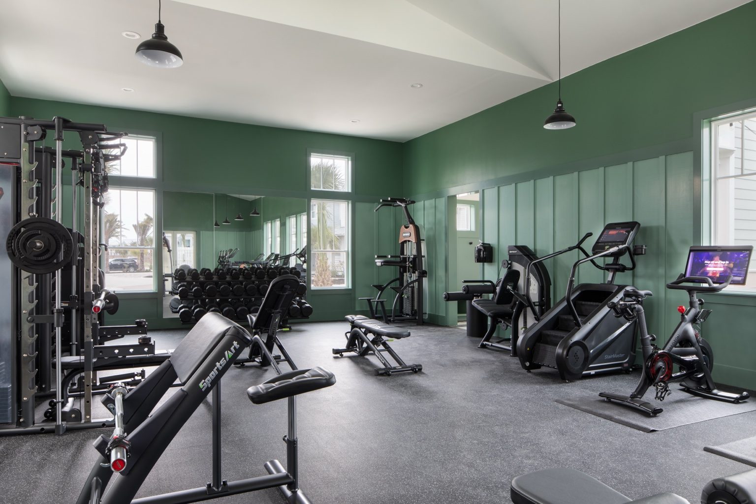 Glow Pool Fitness Center cardio and strength equipment in a green coastal workout room at Cinnamon Shore.