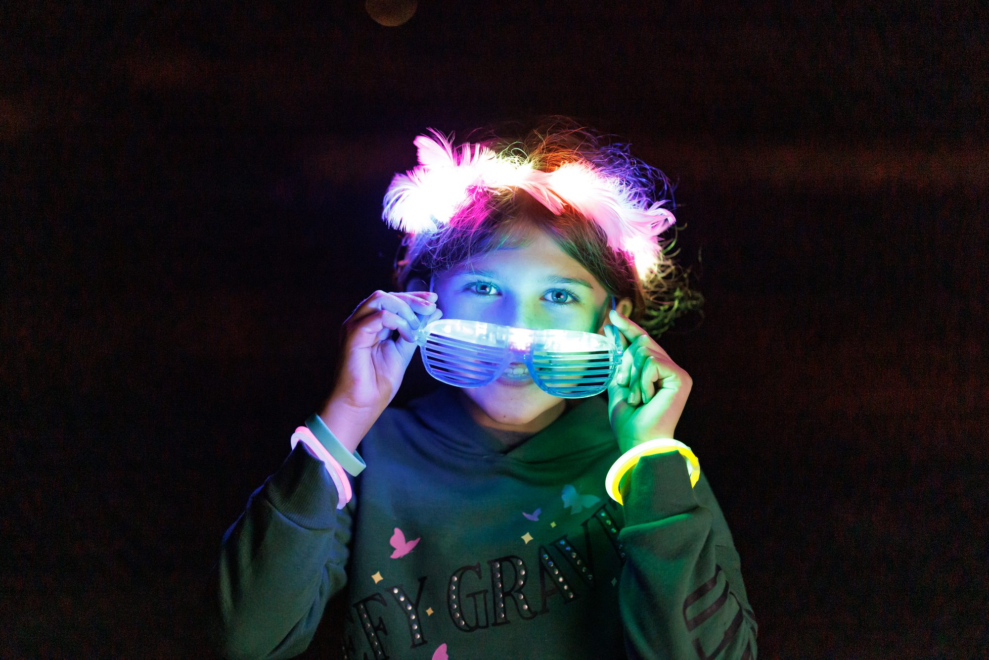 Child in glow lights and a light-up crown at the Cinnamon Shore New Year&rsquo;s Eve glow party in Port Aransas, Texas