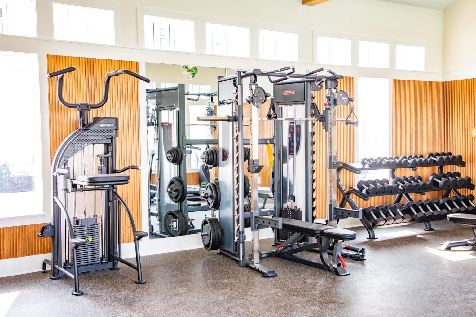 Sea Glass Fitness Center free weights, cardio machines, and strength equipment in a bright Cinnamon Shore amenity space.