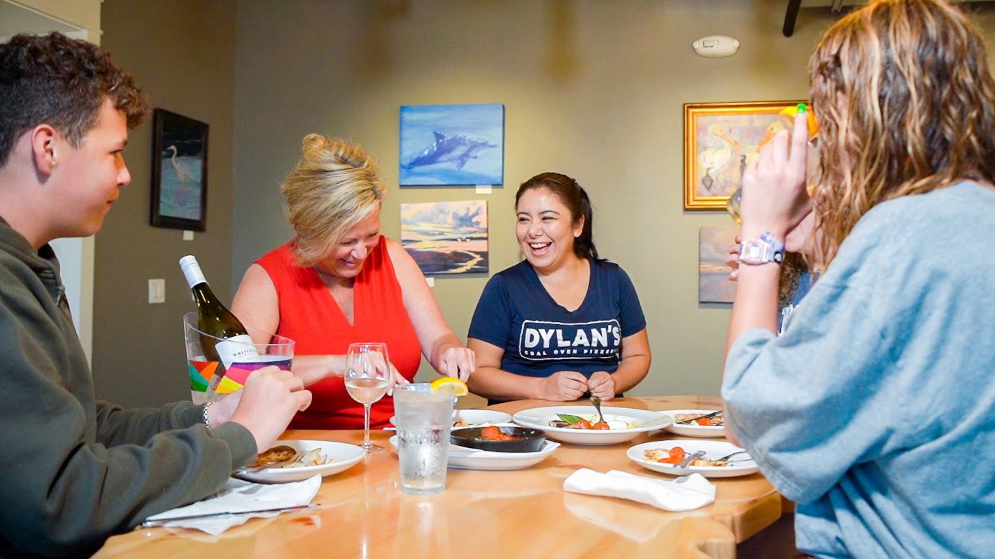 Guests dining together inside Dylan's Pizzeria at Cinnamon Shore