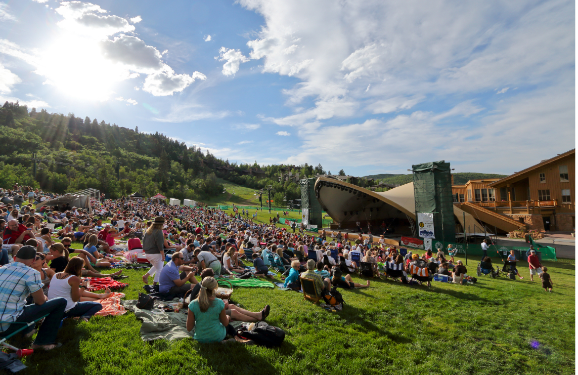 Deer Valley Outdoor Amphitheatre in Park City, Utah with a crowd of people watching a concert.