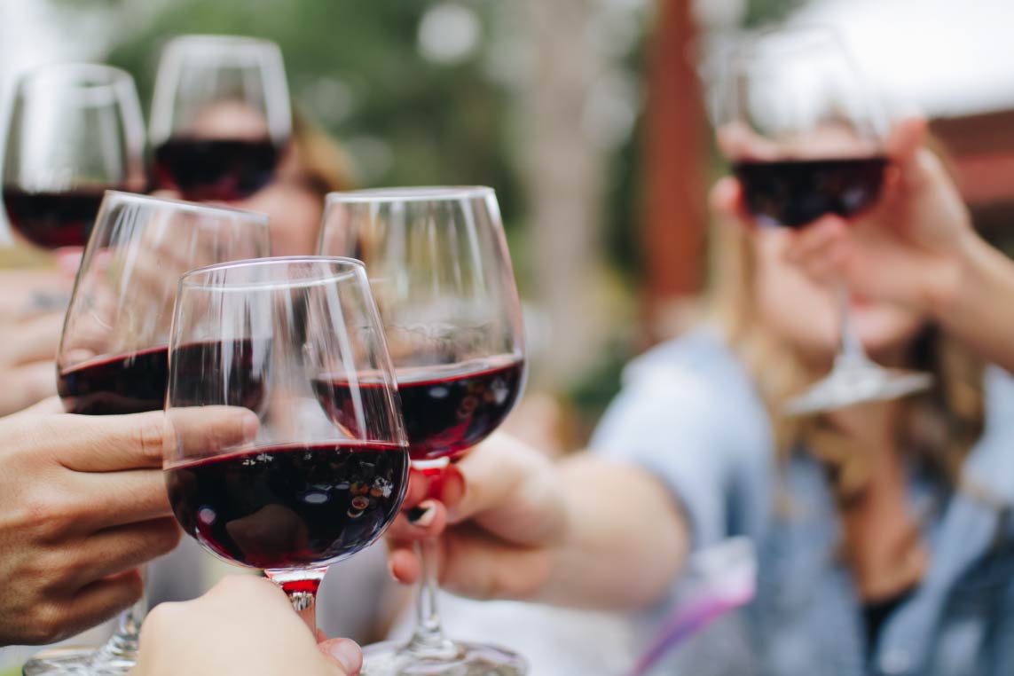 People holding glasses of red wine at Park City, Utah's wine festival.