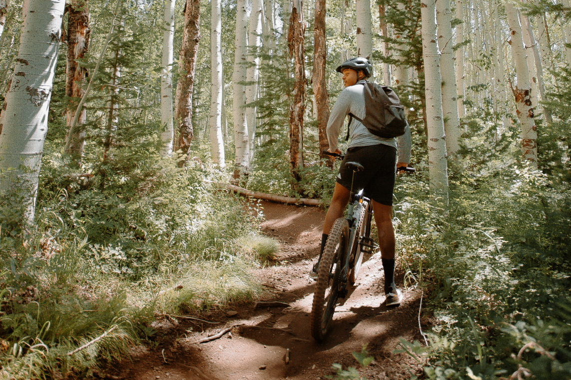 A man mountain bikes through a Park City, Utah forest during a fall vacation.