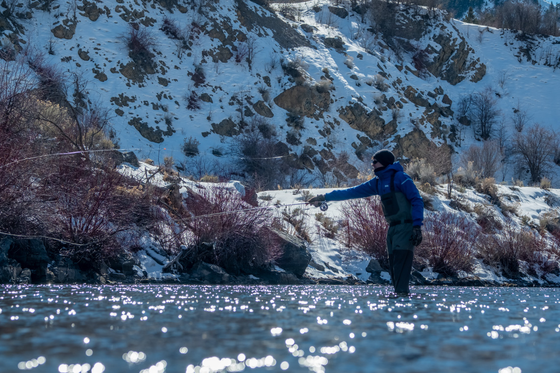 A man fly fishing in Park City during winter.