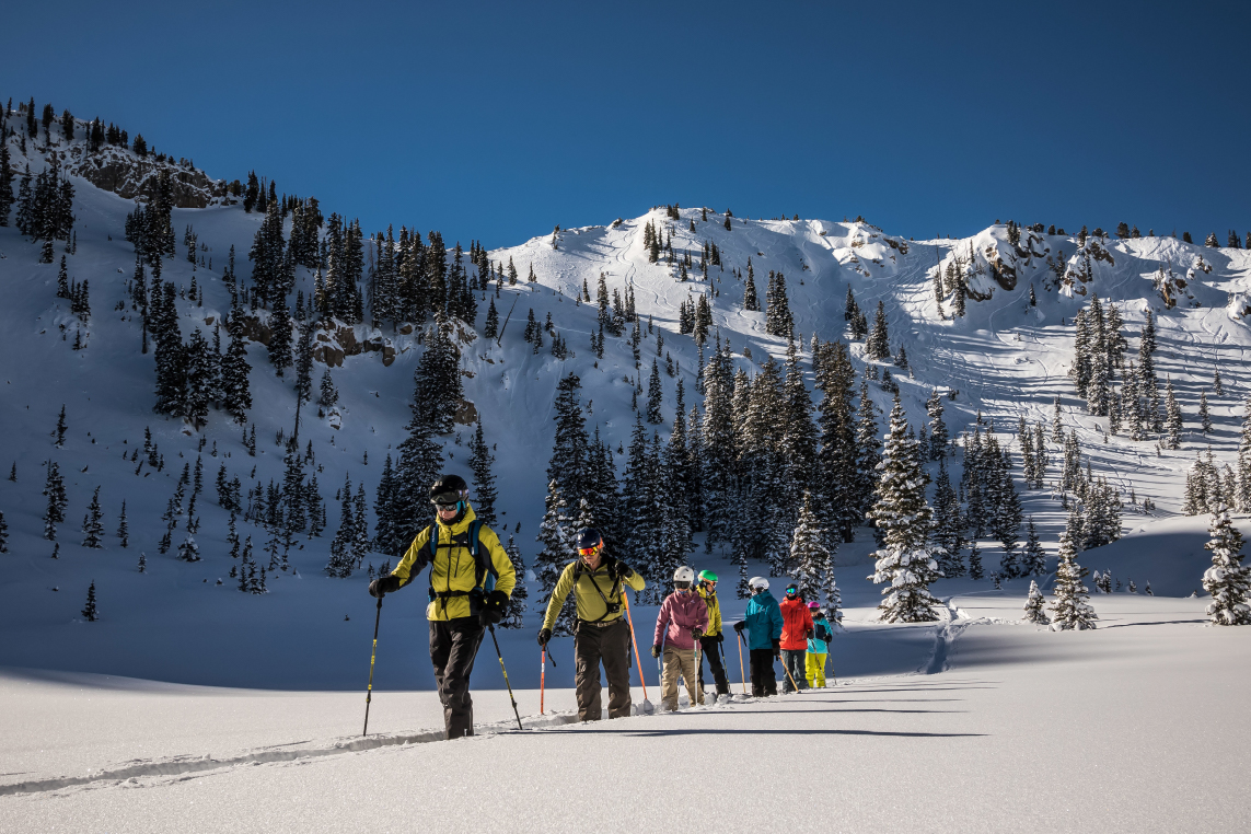 A group of vacationers in Park City cross-country skis on mountains covered in snow.