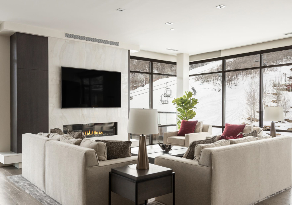 Modern living room decor in Lift complex in Park City with large windows featuring a view of the ski lifts outside. 