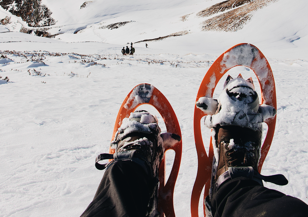 Snowshoes and snowy mountain backdrop. 