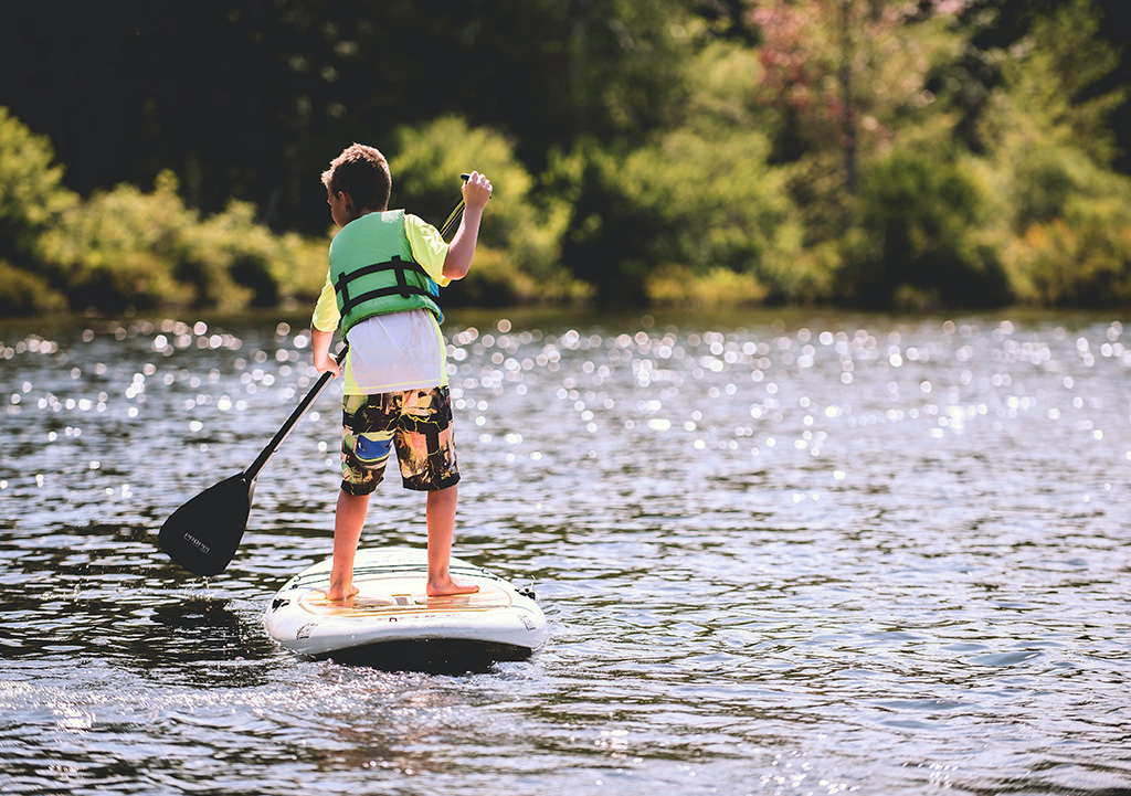 boy stand up paddle boarding