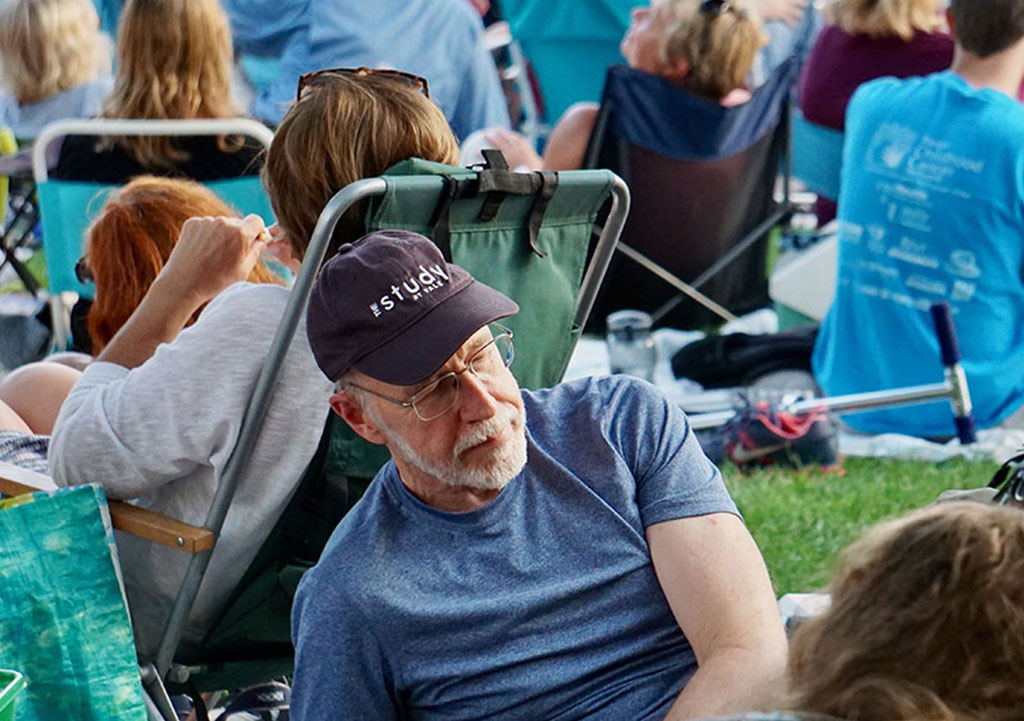people at outdoor concert with folding chairs