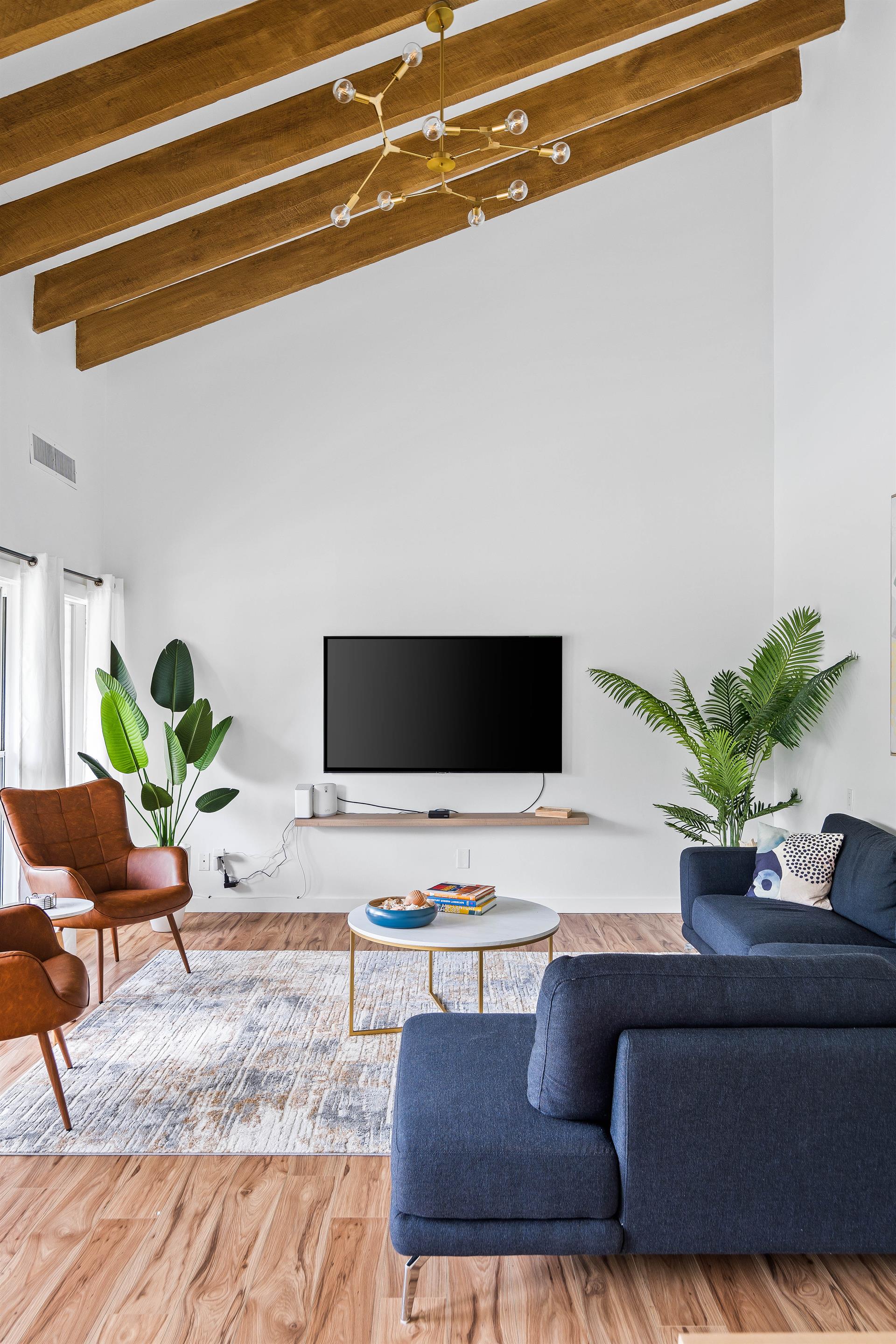 Living room with vaulted ceiling, sectional couch and large flat screen television