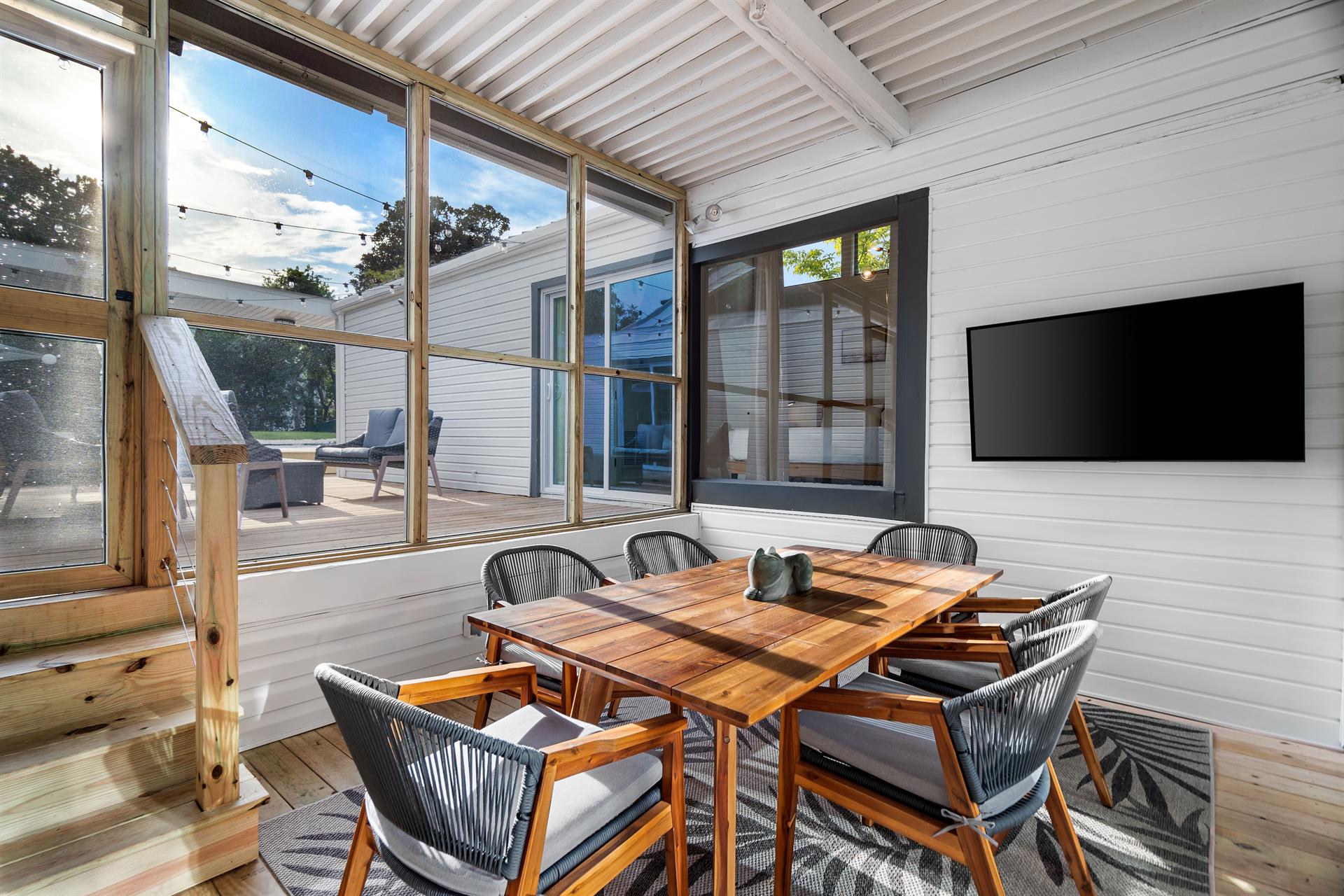 Just off the Kitchen is Another Dining Area Seating on A Covered Screened in Patio with a 58 Smart TV.