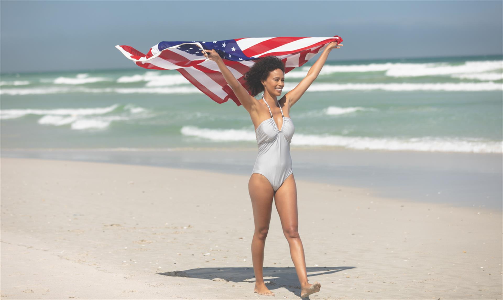 Woman holding American Flag on beaches of Destin