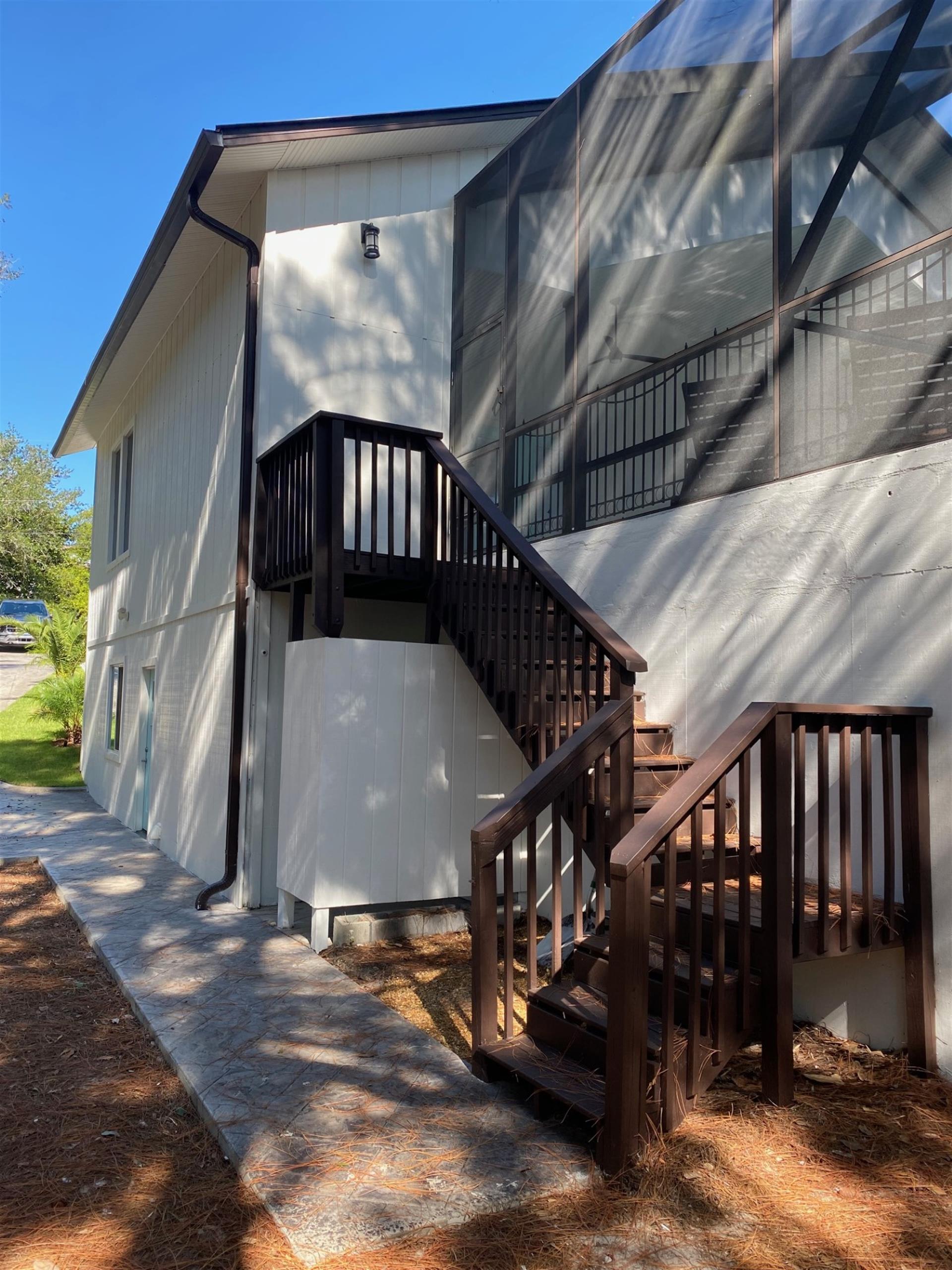 Outdoor Staircase with a semienclosed Outdoor Shower Under the Stairs from Pool Deck