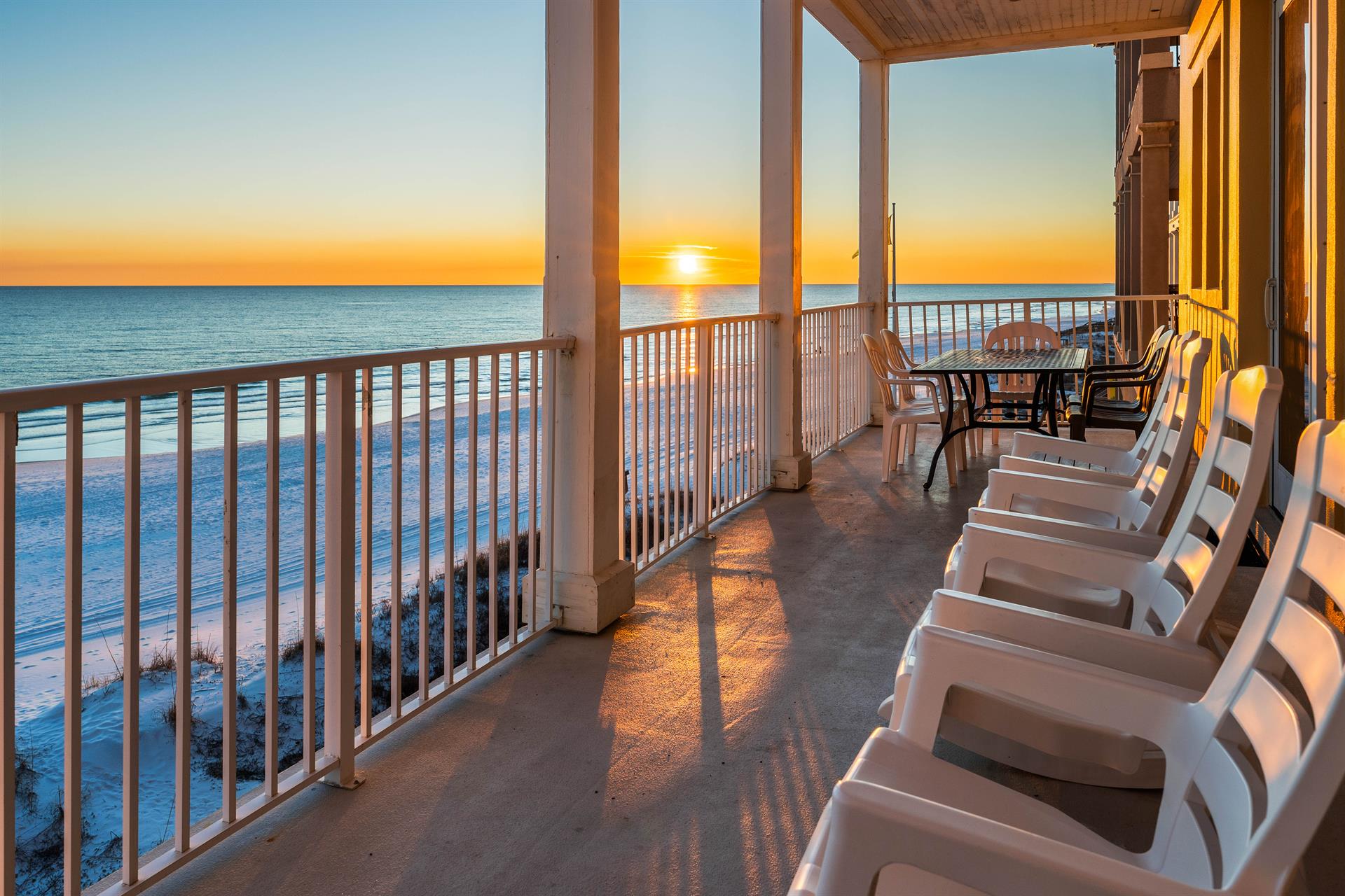 Order up 1 fabulous sunset with your rocking chairs plus outdoor dining table on this 2nd floor balcony