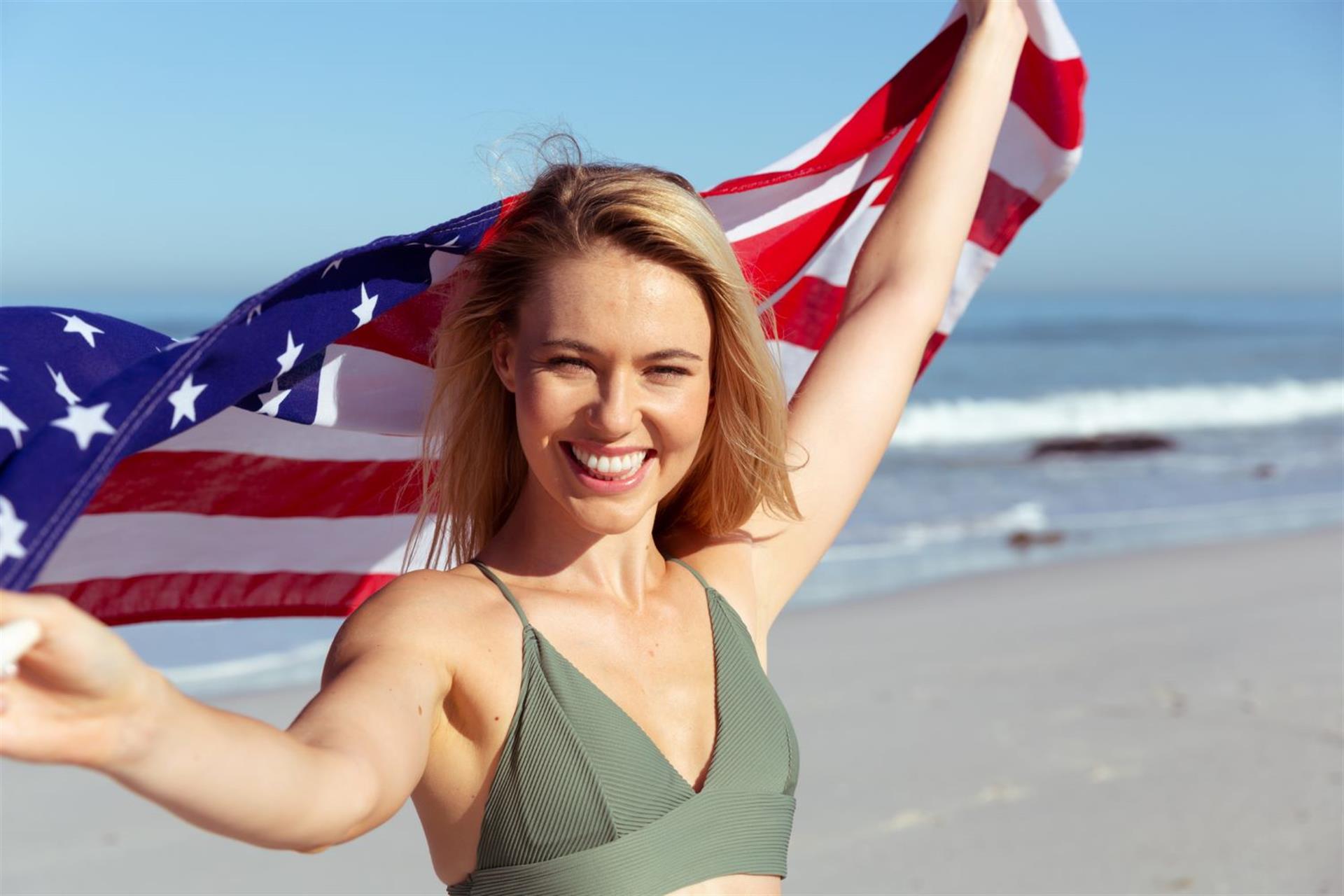 Woman with American flag on beach