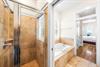 Dual Travertine Vanities with a Separate WalkIn Shower and Soaking Bathtub for the Primary 3rd Floor bedroom.