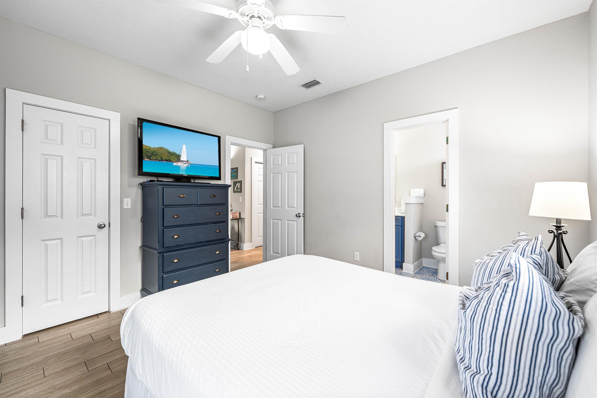 First floor bedroom with a queen bed,42 tv, large walkin closet, additional door out to the front porch, and a full bathroom.