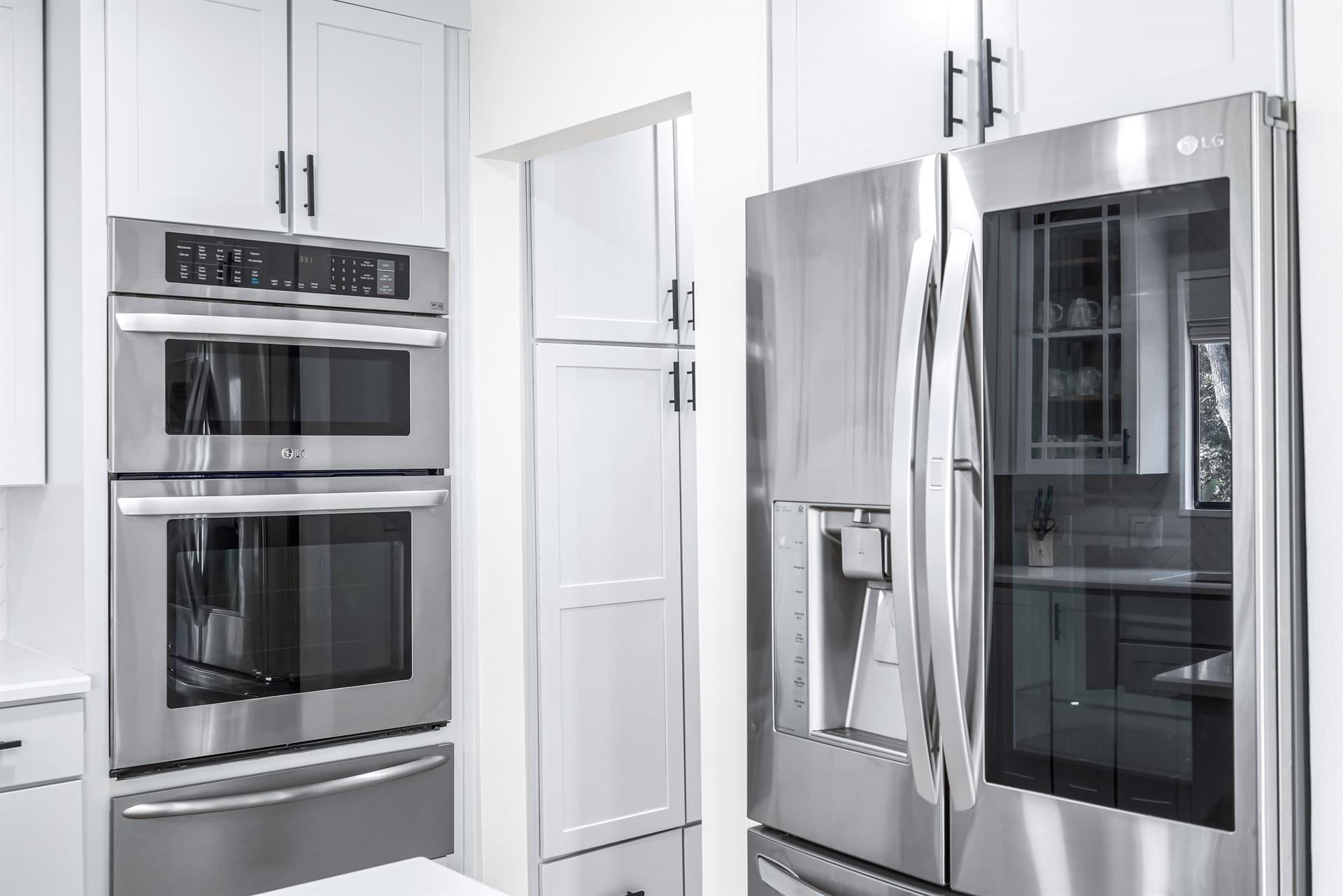 Stainless Steel LG Large Fridge with a Pullout Freezer Drawer Below and a Stainless Frigidaire Oven, Convection Oven and Warming Drawer