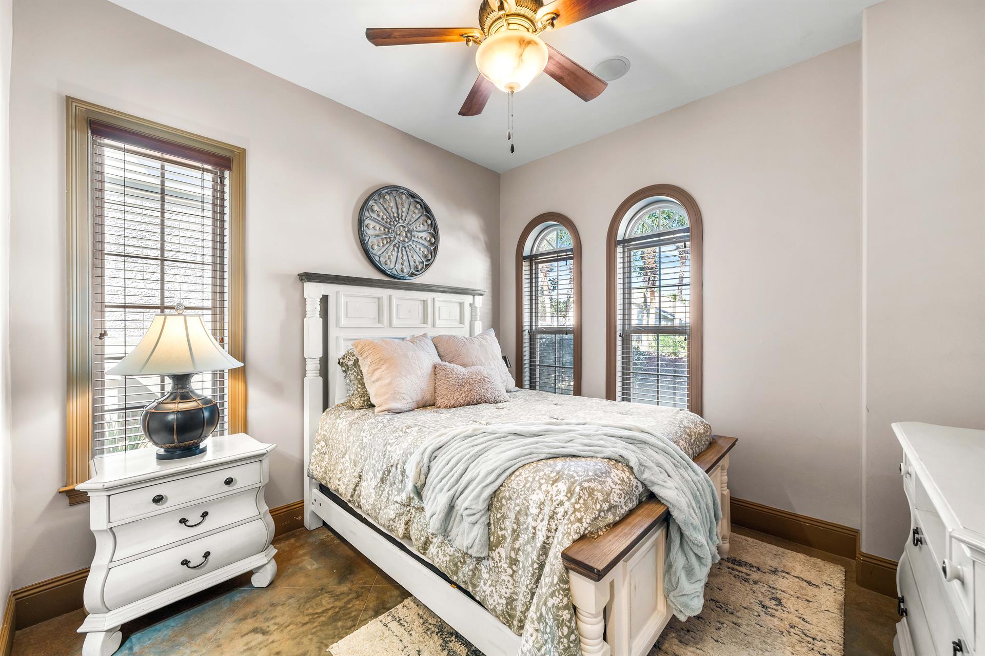 Experience comfort and privacy in this 1st floor bedroom with a queen bed, double arched windows  an en suite bathroom.