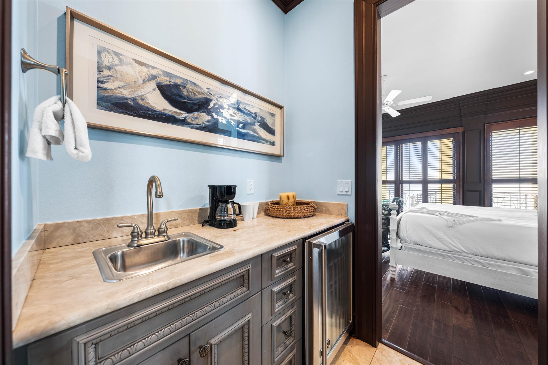 Travertine wet bar with a Keurig and coffee setup and Viking beverage cooler