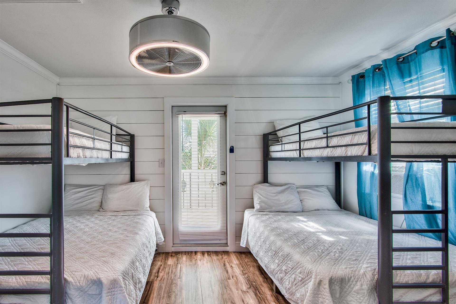 Bunk bedroom with 2 sets of twin over full beds and private balcony with ensuite bathroom with a 24 smart tv.