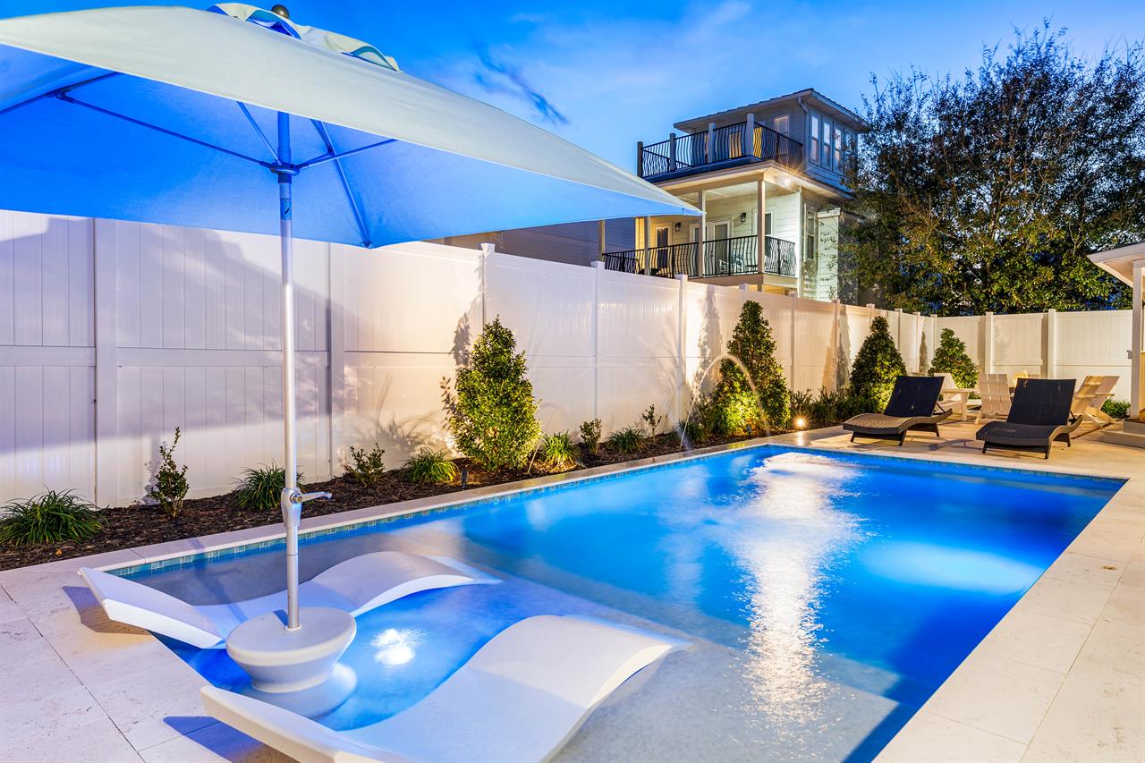 Large Private Pool with Sunshade, in pool lounge chairs Spacious Pool Deck with a Fire Pit and covered Dining Area This Backyard is Completely Enclosed.