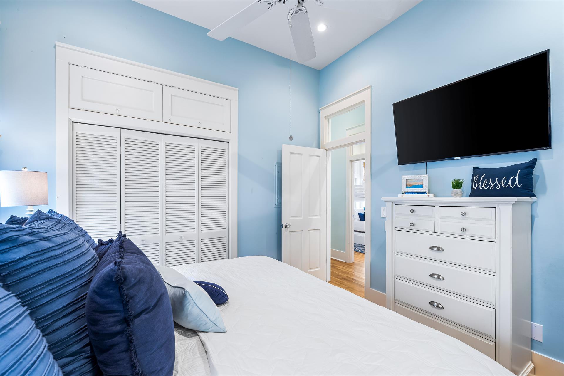 King bedroom with an en suite bathroom, large closet, ceiling  fan, and a 50 Smart TV.  .