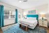 3rd Bedroom is the primary suite on the east end with a king bed, 45 TV,  walkin closet, ensuite full bathroom with a bathtubshower combination, and views of the pool area  door leading out to the