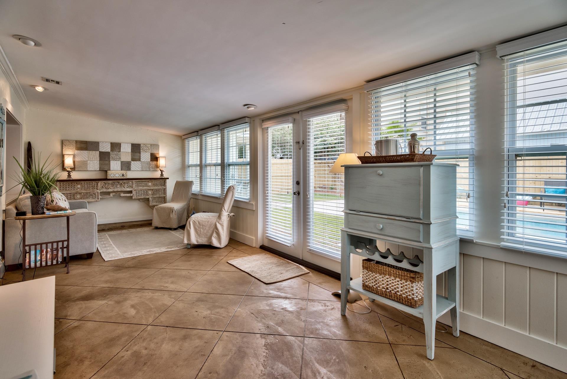 A traditional Florida Room in Seabreeze with a sleeper sofa, bar cabinet, a desk,  access to the pool area through French doors. safety alarm
Fully stocked Beach Gear closet