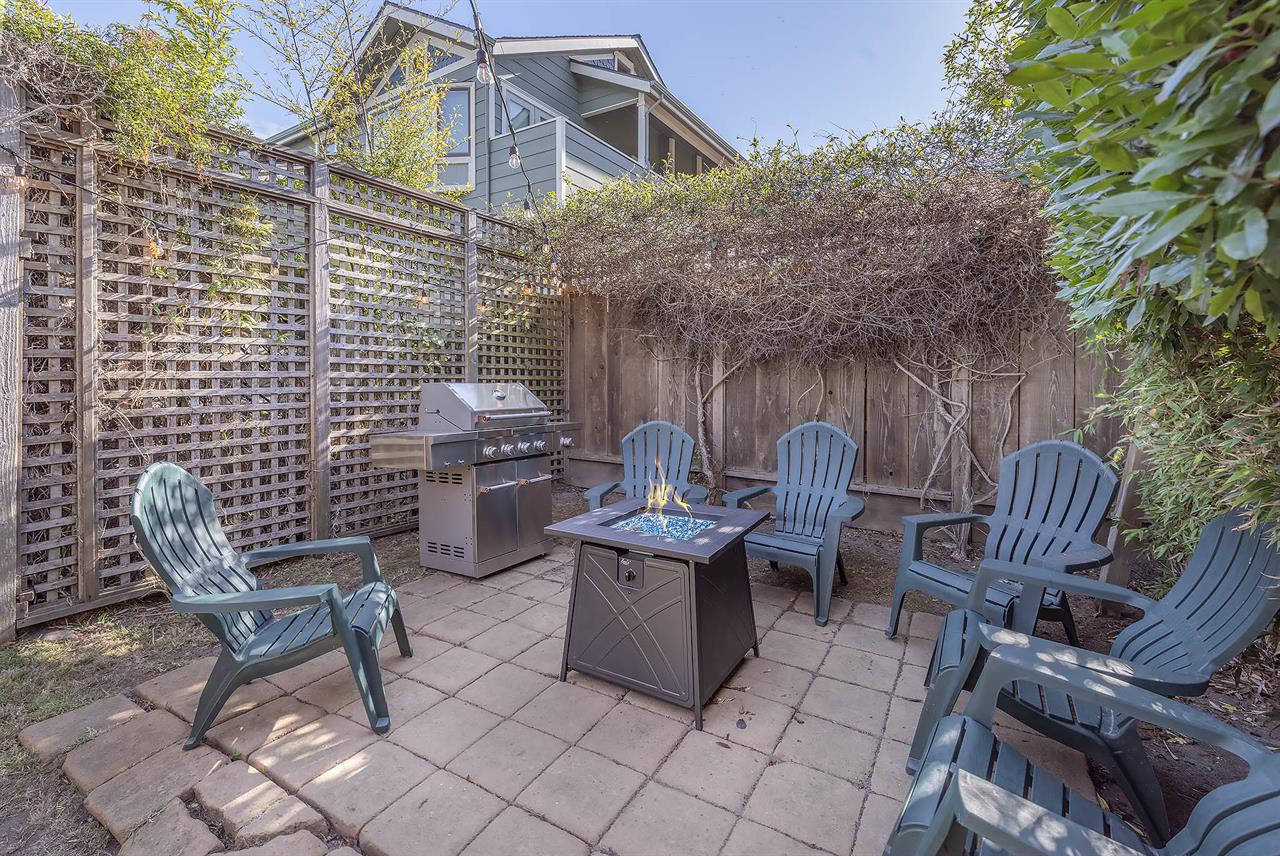 Backyard with fire pit and gas grill.