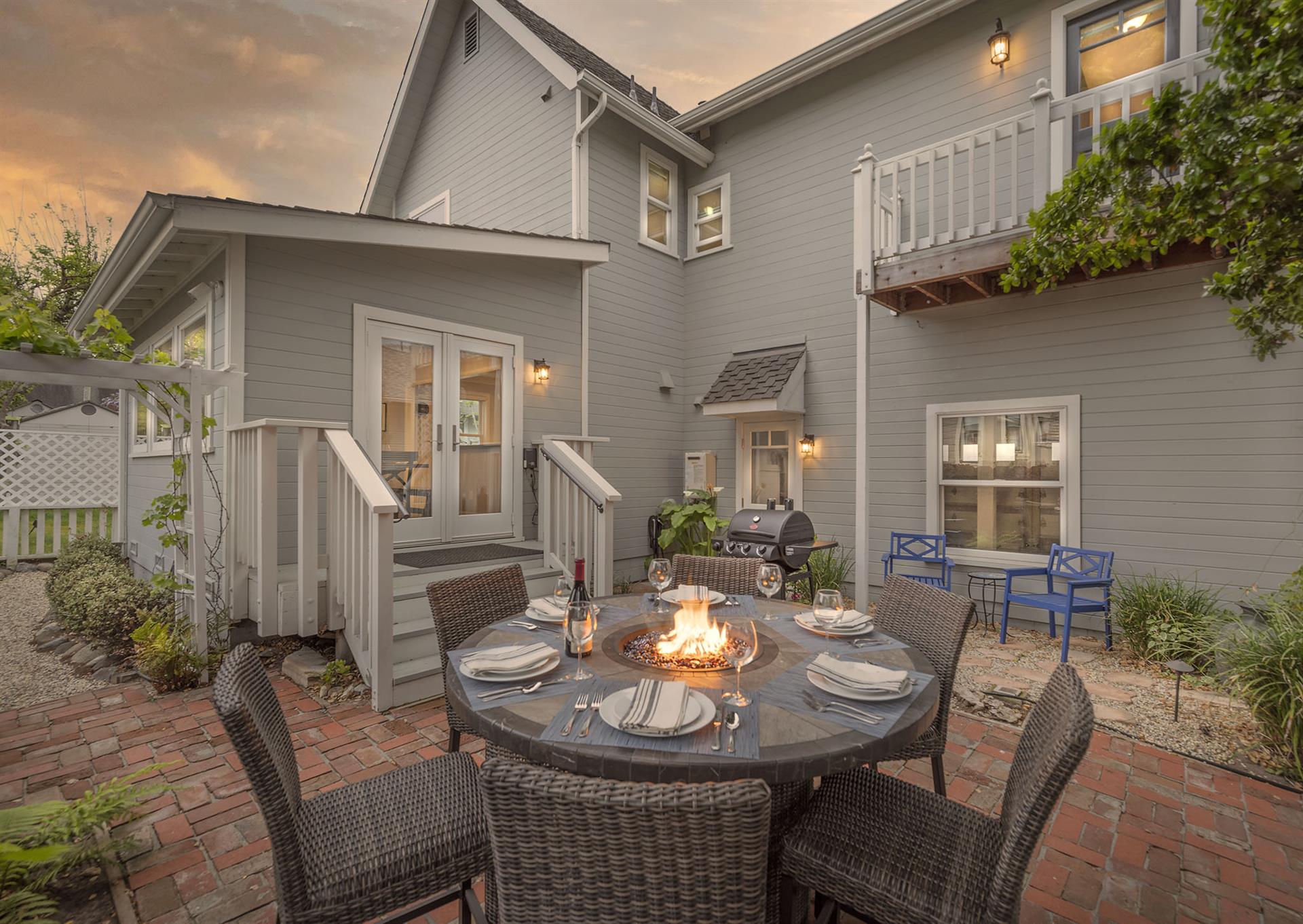 Backyard at Dusk with a Fire Pit Table and Gas BBQ
