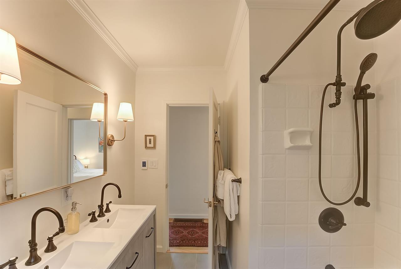 Bathroom has Two Sinks and a ShowerOverTub Combo