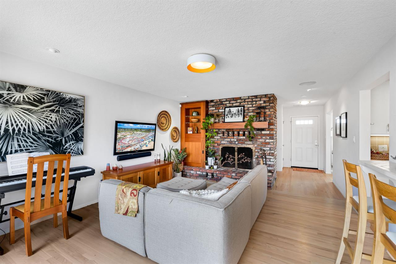 family room has a decorative fireplace with brick surround and , and a