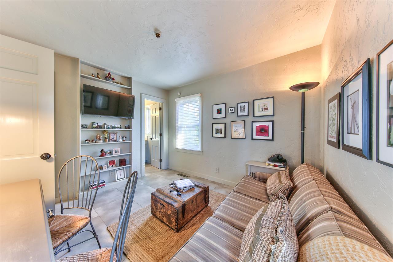 A separate  space is furnished with a  Access to the half bathroom is through the den.