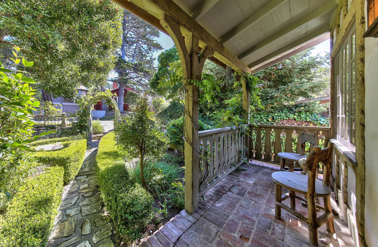 Covered Front Porch Looks Out Onto Mature Garden