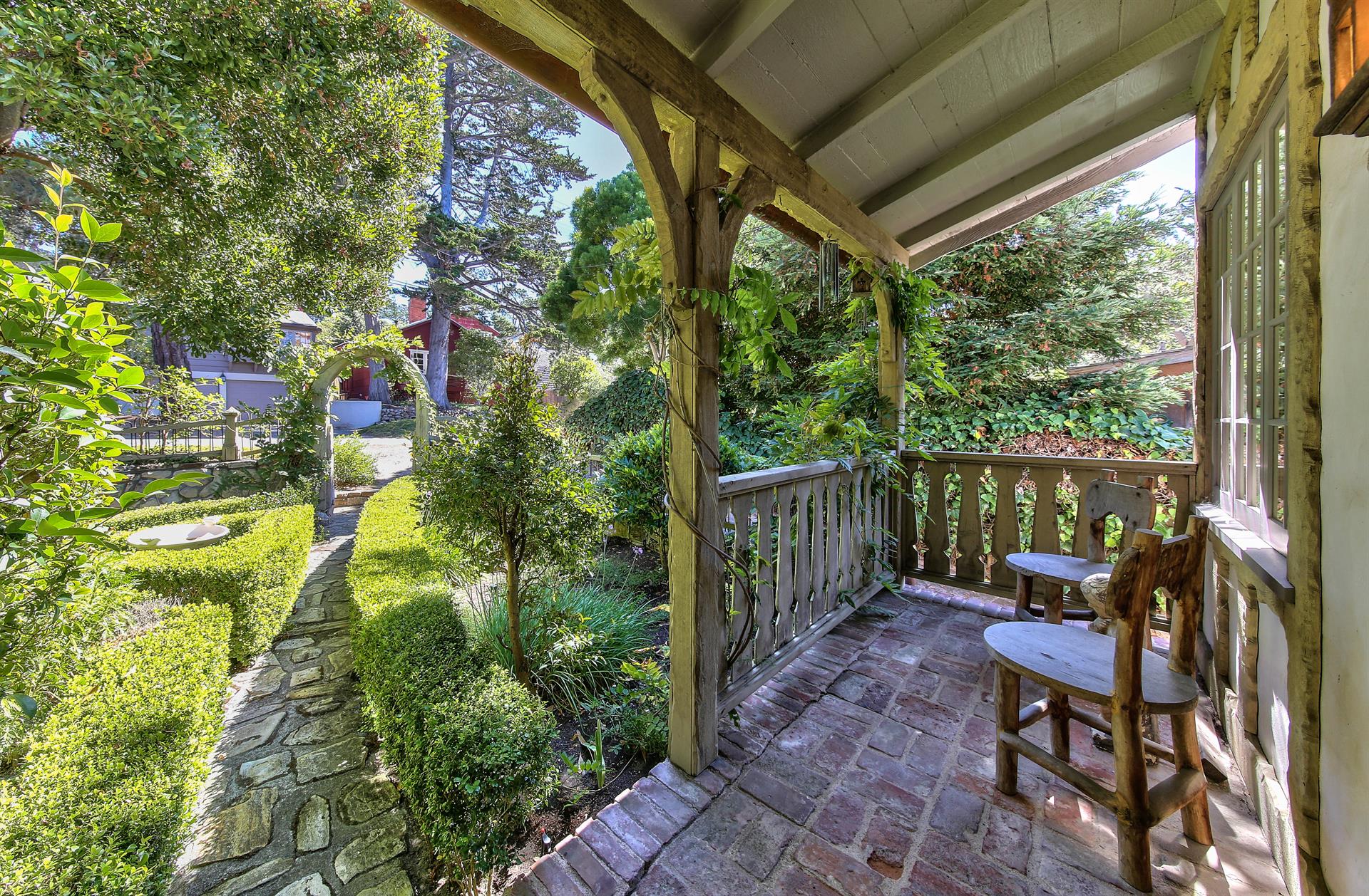 Covered Front Porch Looks Out Onto Mature Garden