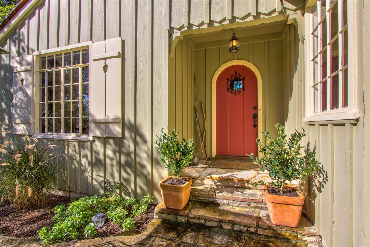 Adorable Home with Arched Door, Board and Batten Siding, Shutter