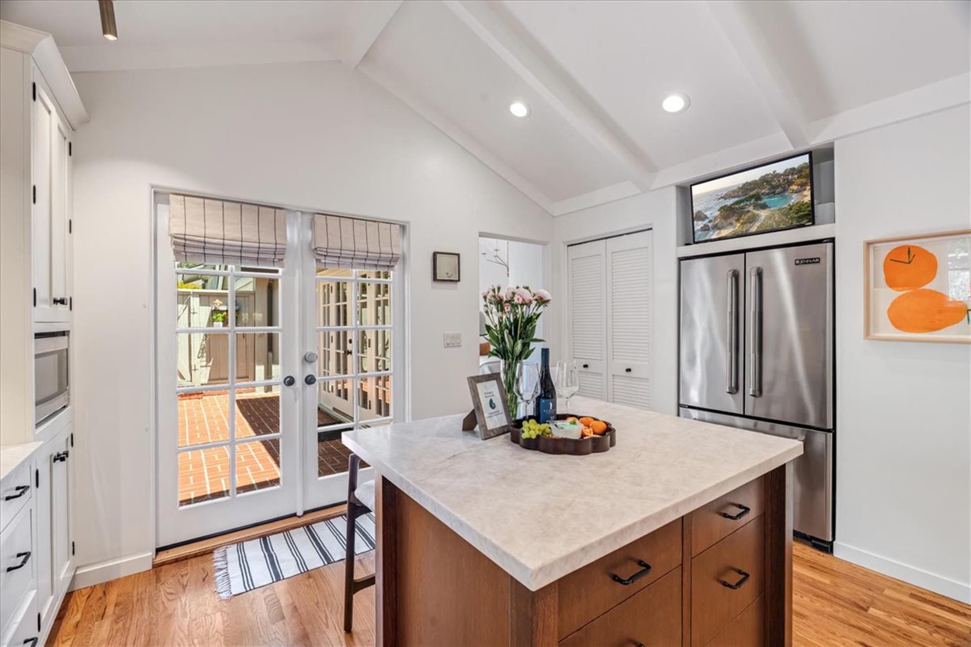 Kitchen has a Smart TV Above the Refrigerator