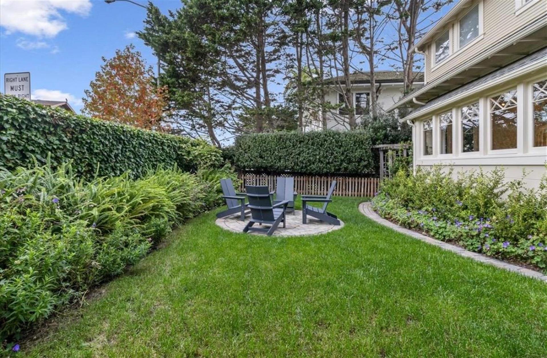 Backyard has Lovely Landscaping and a Seating Area