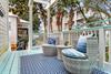 Back deck off  the primary bedroom with barrel shaped wicker seats  a perfect spot for morning coffee.